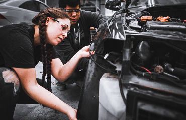 Woman and man working on a car