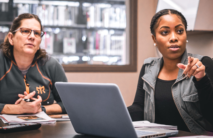 Two women having a discussion in class