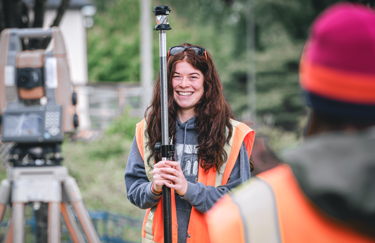 Two people using surveying equipment