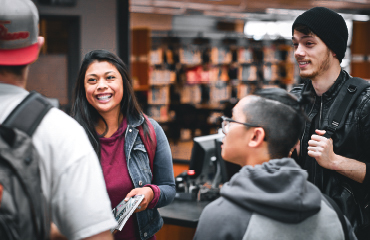 Four people talking in the Library