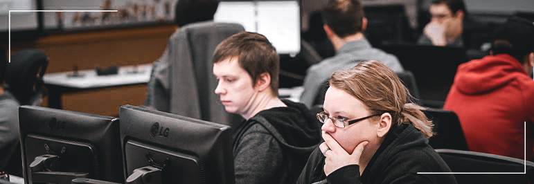 A man and woman looking at a computer